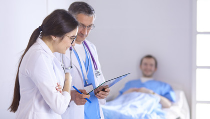 Wall Mural - Doctor checking heart beat of patient in bed with stethoscope