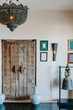 © Annatamila - Old style interior details in luxury interior. Wooden door, big lamp, bell, pictures on the wall