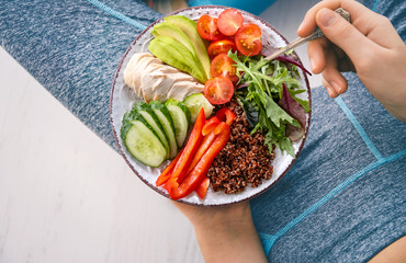 Young woman is resting and eating a healthy food after a workout. Fitness and healthy lifestyle concept.