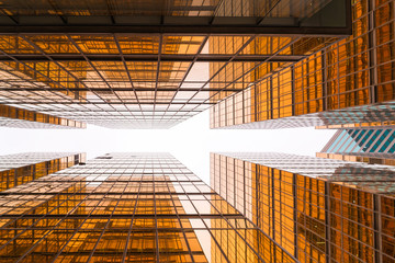 Low angle view of golden glass mirror of modern office buildings in Hong Kong.