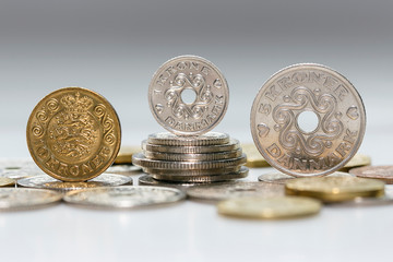 Wall Mural - A ten, one and five krone coin standing on a pile of other Danish coins. The krone is the official currency of Denmark, Greenland, and the Faroe Islands, introduced on 1 January 1875.