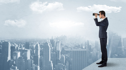 Wall Mural - businessman looking forward to a city with binoculars from skyscraper concept