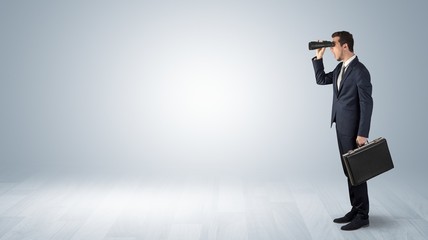 Wall Mural - businessman looking forward with binoculars in an empty space