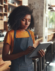 Poster - Female owner using digital tablet at the coffee shop