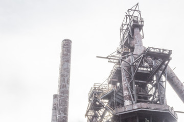 Industrial scene on foggy morning with smokestacks and steel industry complex, horizontal aspect