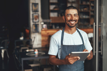 Poster - Smiling male owner standing at the doorway of his cafe