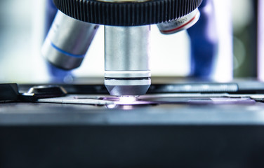 Close up objective lens microscope in laboratory.