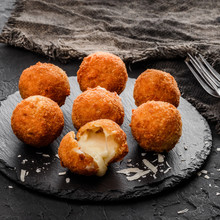 Fried Potato Cheese Balls Or Croquettes With Spices On Black Plate Over Dark Stone Background. Unhealthy Food, Top View