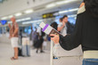 © escapejaja - Closeup of girl holding passports and boarding pass at airport