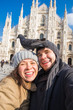 © satura_ - Couple taking self portrait with pigeon in Duomo square in Milan. Winter traveling, Italy and relationship concept