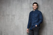 © Damir Khabirov - Positive European Caucasian guy standing against wall in relaxed convenient pose