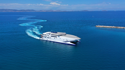 Wall Mural - Aerial drone top view photo of high speed passenger ferry arriving at port of Mykonos island, Cyclades, Aegean sea, Greece