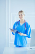 © lenets_tan - Smiling female doctor with a folder in uniform standing