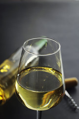 Wall Mural - Transparent bottle of white dry wine on the table. White wine glass on a wooden background.