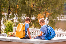 Two Boys After School, Sitting On Bench And Talking