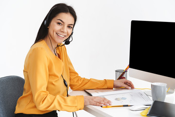 Sticker - Image of joyful woman wearing microphone headset using paper charts and graphs while working in office