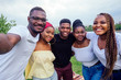 © yurakrasil - group of five friends female and male taking selfie on camera smartphone and having fun outdoors lifestyle near lake