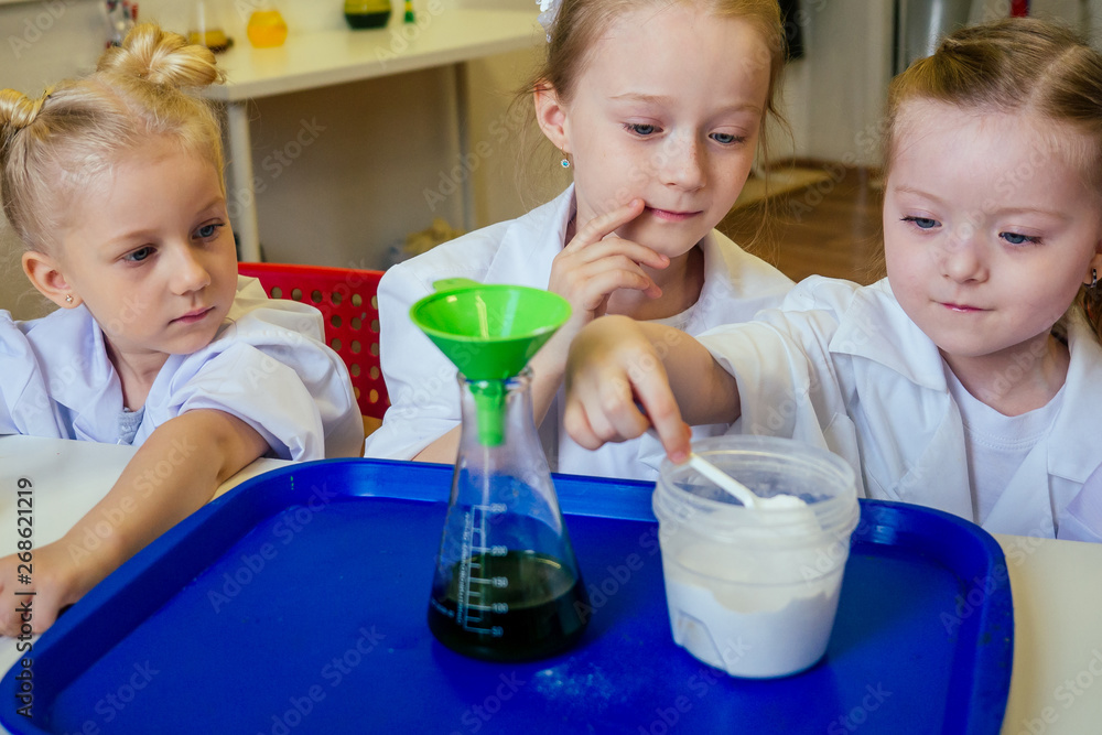 group of school girl kids with teacher in school laboratory making ...