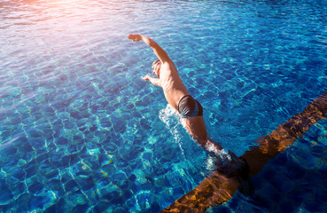 Young athletic man swimming in the swimming pool