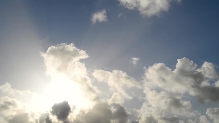 Wall Mural - Time-lapse of clouds, sun rays and beams, airplanes and birds moving through a foggy, misty sky.