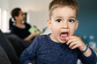 © Miljan Živković - Portrait of a little small boy eating unhealthy snacks potato chips at home