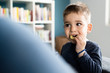 © Miljan Živković - Portrait of a little small boy eating unhealthy snacks potato chips at home