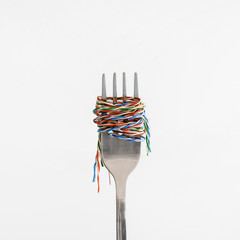 utp cable wrapped around a steel fork like pasta or spaghetti on the white background.