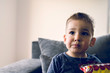 © Miljan Živković - Portrait of a little small boy eating unhealthy snacks corn peanut flips at home