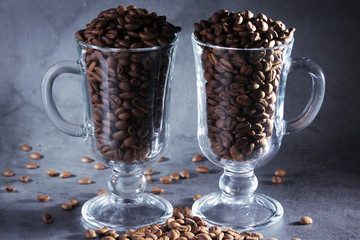 Two glasses full of coffee beans with cinnamon as a concept of coffee drinking	