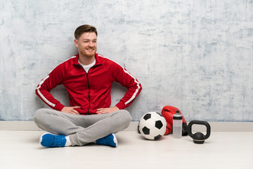 Wall Mural - Redhead sport man posing with arms at hip and smiling