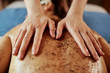 © DragonImages - Beautician scrubbing back of client