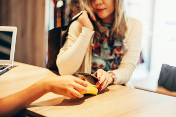 Wall Mural - Woman paying with NFC technology on mobile phone, restaurant, cafe, bar, clothing store