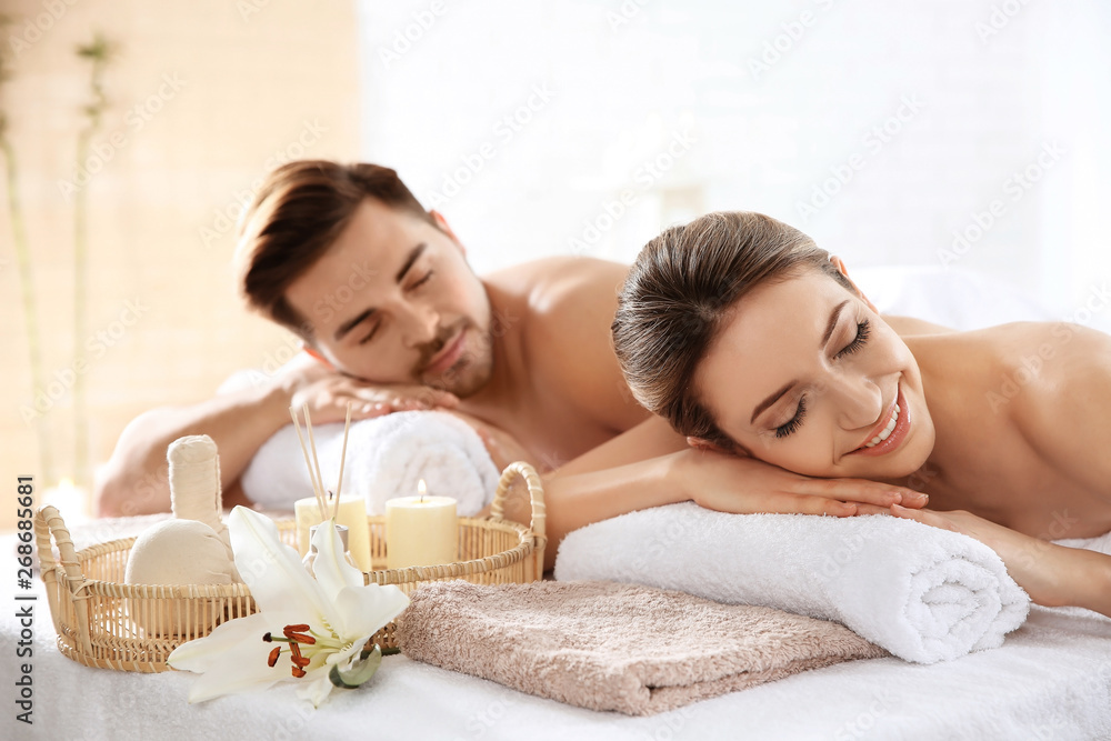 Young couple with spa essentials in wellness center - obrazy, fototapety, plakaty 