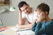 Dad struggling to help his son with school assignment at home
