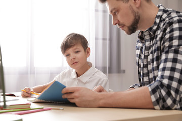 Canvas Print - Dad helping his son with school assignment at home