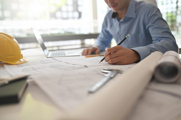 Cropped shot Architect working on drawing table with pencil.