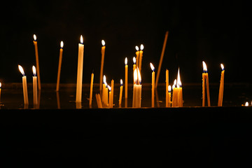 Wax candles burning with fire on background