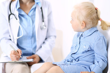 Doctor and a little blonde girl. Usual health exam. Medicine and healthcare concept