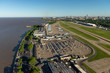 Aerial image showing the full Aeroparque Internacional Ing. Jorge Alejandro Newbery at the river Rio de la Plata with the city of Buenos Aires in the background.