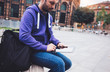 © A_B_C - Hipster texting message on tablet computer or technology screen mockup. Smile young man using digital on building castle background. Male hands tourist holding gadget on blur cityscape