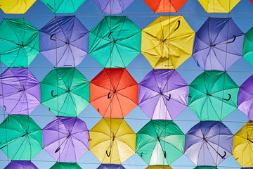 Poster - The image of colorful umbrellas on a background of blue sky