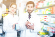 © JackF - Two pharmacists are inventorying medicines with note near shelves in apothecary.