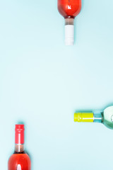 Wall Mural - Screw bottle foil caps in different bright colors of white and rose wine bottles on blue background with copy space. Minimal abstract colorful mockup concept of alcohol beverage. Flat lay.
