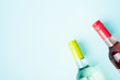 Screw bottle foil caps in different bright colors of white and rose wine bottles on blue background with copy space. Minimal abstract colorful mockup concept of alcohol beverage. Flat lay.