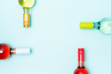 Wall Mural - Mockup frame of bottle foil caps in different bright colors of white and rose wine bottles on blue background with copy space. Minimal abstract colorful mockup concept of alcohol beverage. Flat lay.