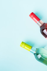 Wall Mural - Screw bottle foil caps in different bright colors of white and rose wine bottles on blue background with copy space. Minimal abstract colorful mockup concept of alcohol beverage. Flat lay.