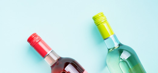 Wall Mural - Screw bottle foil caps in different bright colors of white and rose wine bottles on blue background with copy space. Minimal abstract colorful mockup concept of alcohol beverage. Flat lay.