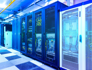 Server room with control modules in racks datacenter under blue toning