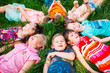 © davit85 - A group of children lying on the green grass in the Park. The interaction of the children.