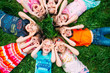 © davit85 - A group of children lying on the green grass in the Park. The interaction of the children.